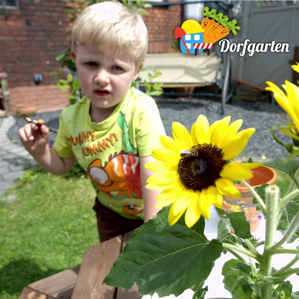 Ein Kind hält einen Pinsel, im Vordergrund steht eine Sonnenblume © Thorsten Rogsch